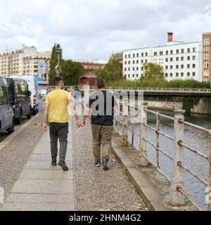 Sentiero sulla riva del fiume Sprea a Berlino con coppia omosessuale a piedi Foto Stock