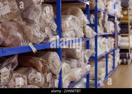 Interno di un magazzino industriale con rotoli di tessuto. Foto Stock