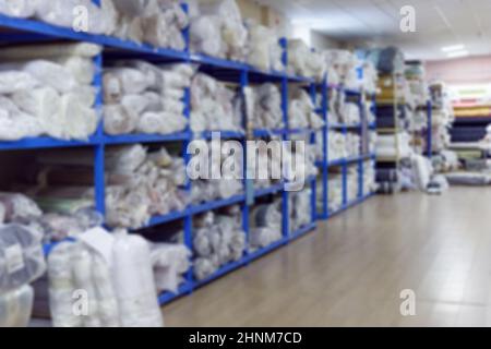 Interno sfocato del magazzino industriale con rotoli di tessuto Foto Stock