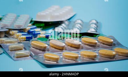 Confezioni blister di integratori e pillole isolate su sfondo blu, primo piano. Foto Stock