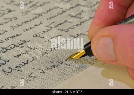 Primo piano di una mano maschio pronta a scrivere con un elegante penna stilografica. Lettera di scrittura a mano con penna stilografica Foto Stock