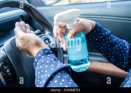 New Normal, Asian lavoro donna lavaggio mano da press blu alcol sanitizzante gel per proteggere la sicurezza Coronavirus in auto. Foto Stock
