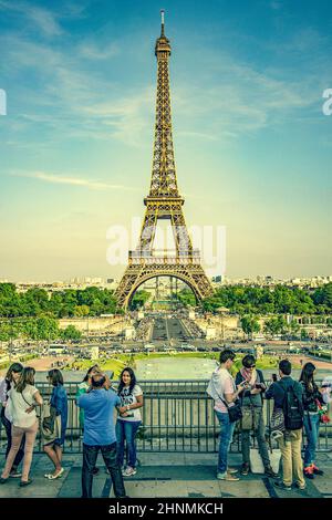 I turisti scattano foto di fronte alla Torre Eiffel di Parigi Foto Stock