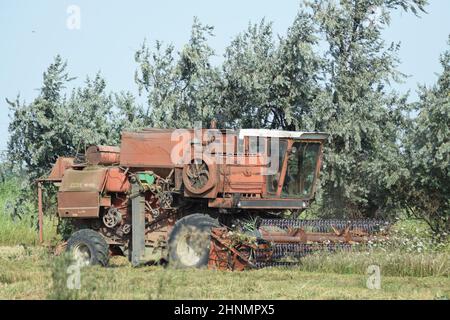 Vecchio arrugginito mietitrebbia. Foto Stock