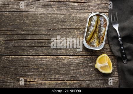 Sardine in scatola. Pesce di mare in lattina su tavola di legno. Vista dall'alto. Foto Stock