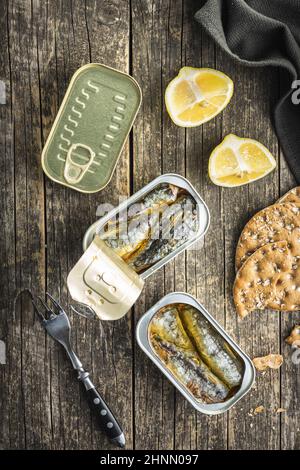 Sardine in scatola. Pesce di mare in lattina su tavola di legno. Vista dall'alto. Foto Stock