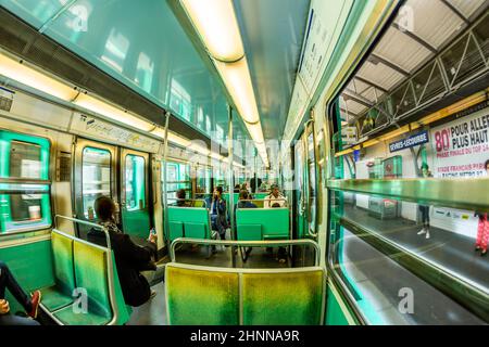 Turisti e locali su un treno della metropolitana a Parigi Foto Stock