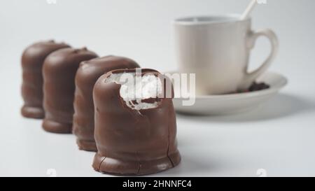 Krembo al cioccolato bianco sul tavolo. Una crema di marshmallow ricoperta di cioccolato che è popolare in Israele. Foto Stock