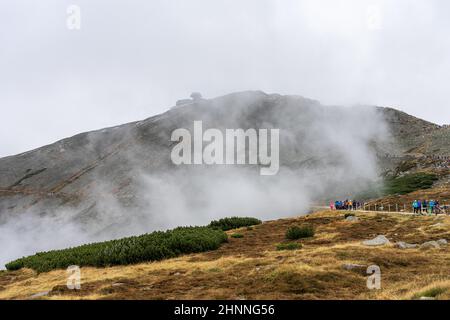 KARPACZ, POLONIA - 16 OTTOBRE 2021: I turisti salgono la popolare vetta della montagna polacca - Sniezka nelle montagne giganti in tempo nuvoloso. Foto Stock