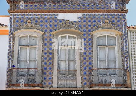 Facciata in piastrelle blu e giallo-vecchia casa cittadina abbandonata-balconi chiusi. Tavira-Portogallo-110 Foto Stock