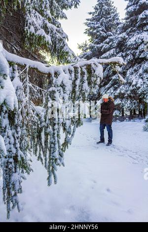 Escursionista nella foresta tedesca nevicato nel paesaggio Brocken Harz Germania Foto Stock