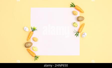 Carta di Pasqua carta carta spazio copia con uova e carote su sfondo giallo pastello chiaro. Disposizione piatta minima. Organizzazione creativa delle vacanze di primavera Foto Stock