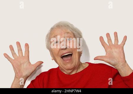 Il ritratto di una donna anziana sorpresa su sfondo bianco Foto Stock