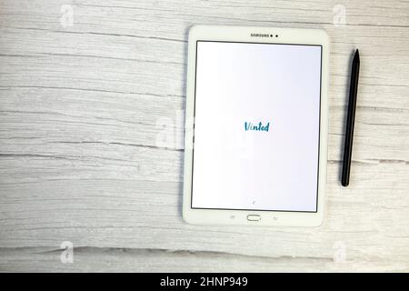 Olanda, dicembre 2021 applicazione mobile Vinted su tablet digitale bianco vista dall'alto su scrivania in legno. Vendita di spazio copia abiti usati Foto Stock