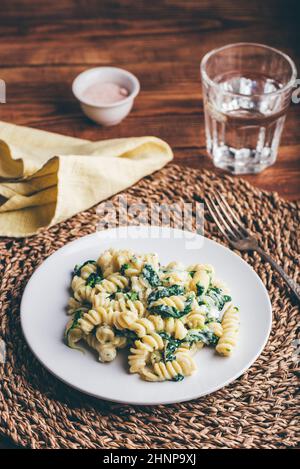 Pasta cremosa con spinaci e Timo su piatto bianco Foto Stock