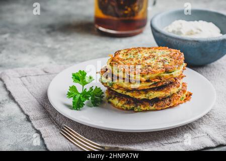 Zucchini frittelle di parmigiano con salsa e prezzemolo Foto Stock