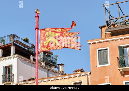 Bandiera di Venezia sullo sfondo della tradizionale architettura italiana Foto Stock