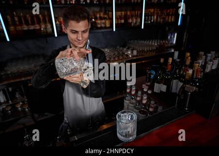 Il barista maschile professionista crea un cocktail alcolico Foto Stock