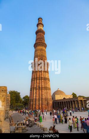 La gente visita Qutb Minar, Delhi, il minareto costruito in mattoni più alto del mondo Foto Stock