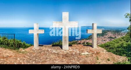 Le tre Iconiche Croci sulla cima del Monte Sant'Elia si affacciano sulla città di Palmi sul Mar Tirreno, in Italia Foto Stock