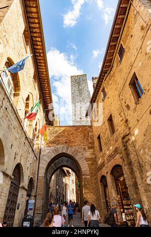 Antica piazza medievale e torri nella tipica cittadina toscana di San Gimignano, famosa meta turistica. Città chiamata anche Manhattan medievale per le torri residenziali che si trovano in essa. Foto Stock