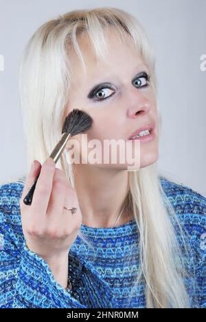 Donna di applicare il trucco Foto Stock