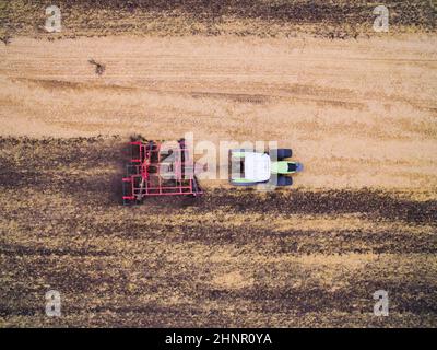 Raccolta sul campo. Vista aerea. Coltivazione del terreno con un trattore Foto Stock