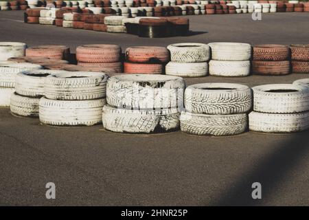 Barriera di sicurezza pista da gara. Pista asfalto con gomme rosse e bianche. Cataste colorate. Pista Karting Foto Stock