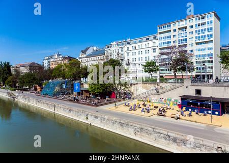 La gente si rilassa sulla spiaggia del canale del Danubio a Vienna Foto Stock