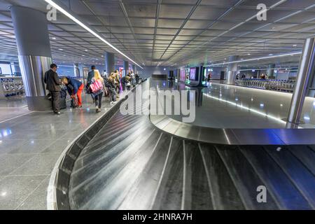 La gente aspetta i bagagli presso la cintura bagagli dell'aeroporto di Francoforte Foto Stock