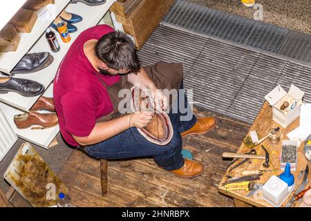 Il calzolaio apre il suo negozio all'annuale festa di Bahnhofsviertel per mostrare il suo artigianato Foto Stock