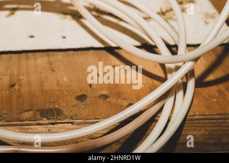 Il cavo bianco si trova sul tavolo in legno. Il cavo di collegamento si avvicina Foto Stock