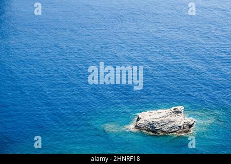 primo piano vista dall'alto di roccia solitaria circondata da azzurro mare blu Foto Stock