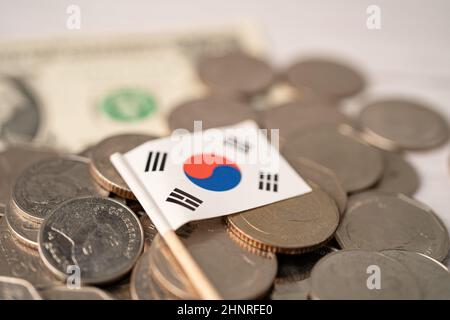 Pila di monete con bandiera coreana su sfondo bianco. Foto Stock