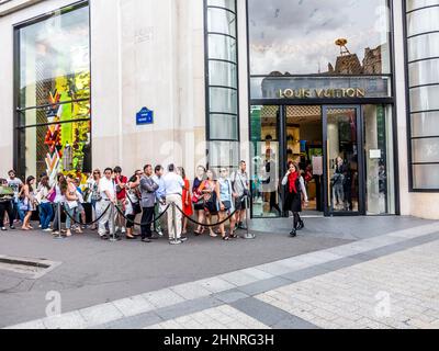 La gente si accoda davanti al negozio Louis Vuitton Foto Stock