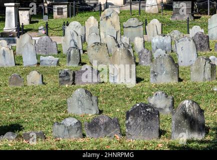 File di pietre di testa sotto un albero alla terra di sepoltura di Granary. Divenne un cimitero nel 1660, il terzo più antico della città di Boston, Massachusetts Foto Stock