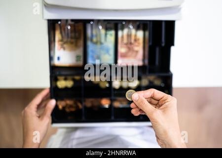 Mano del cassiere che lavora con il registro di cassa che cambia la fattura di soldi Foto Stock