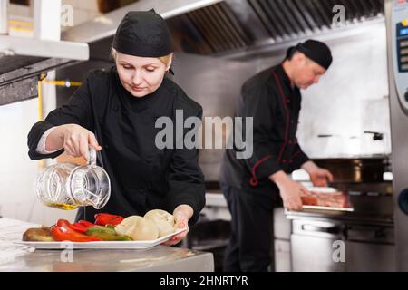 Cuoca femminile che lavora nella cucina del ristorante Foto Stock
