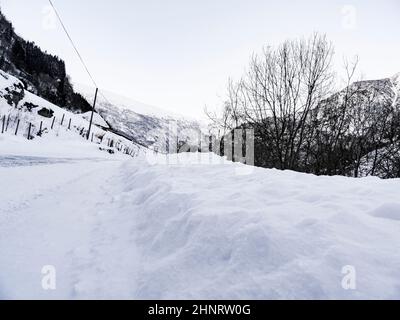 Strada innevata nel paesaggio invernale di Framfjorden, Vestland, Vik, Norvegia. Foto Stock