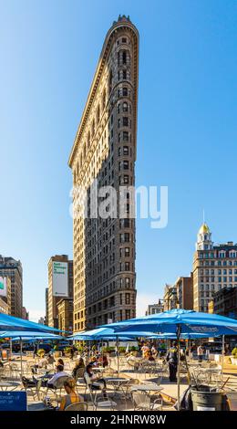 La gente gode di sedersi sulle sedie pubbliche di Broadwayon con wlan gratuito e guardare alla spettacolare facciata dell'edificio Flatiron Foto Stock