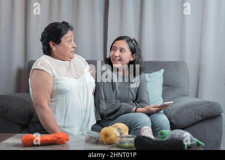 donna più anziana 60 anni nonna latina usando il telefono cellulare e divertirsi con la nipote scattando foto e guardando video Foto Stock