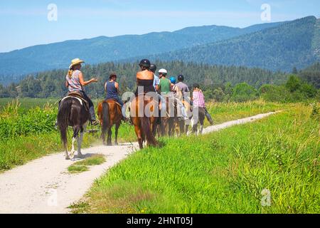 Un gruppo di persone a cavallo che vanno per un giro su un sentiero. Foto Stock