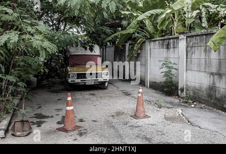 Abbandonata vecchia auto nella foresta tropicale a Bangkok Thailandia. Foto Stock