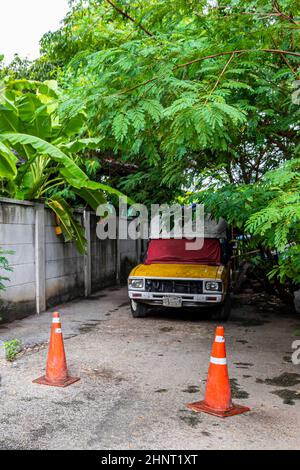 Abbandonata vecchia auto nella foresta tropicale a Bangkok Thailandia. Foto Stock