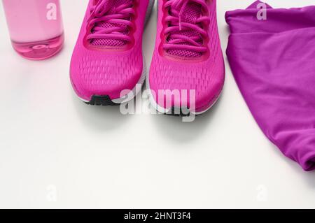 un paio di sneaker sportive in tessuto viola su sfondo bianco. Abbigliamento sportivo Foto Stock