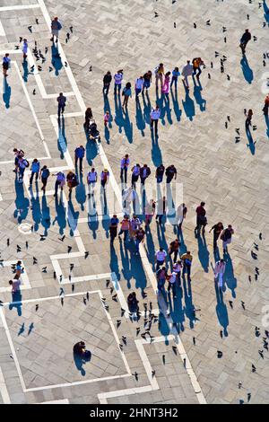 I turisti in piazza San Marco nutrono grandi greggi di piccioni Foto Stock