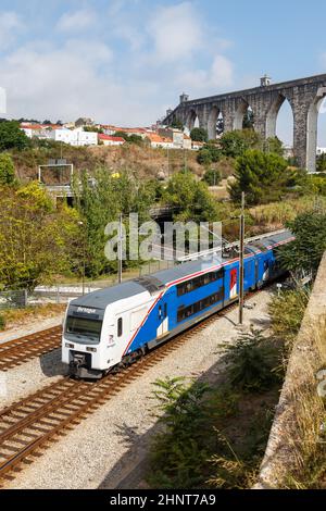 Treno ferroviario di Fertagus all'acquedotto Aqueduto das Aguas Livres a Lisbona Lisboa Portugal in formato ritratto Foto Stock