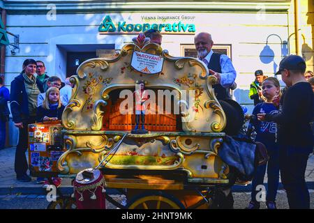 Artista di strada che suona su un organo a botte. Gli organi a botte sono preziosi perché conservano vecchi stili di ornamento musicale. Gli artisti di strada possono ingannare i passanti e intrattenere i turisti. Foto Stock