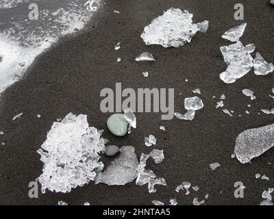 Incredibili pezzi dell'iceberg brillano sulla famosa Diamond Beach alla laguna di Jokulsarlon durante il tramonto Foto Stock