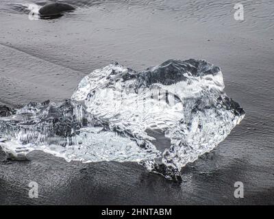 Incredibili pezzi dell'iceberg brillano sulla famosa Diamond Beach alla laguna di Jokulsarlon durante il tramonto Foto Stock